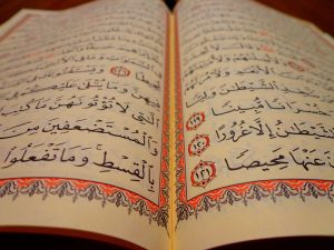 An open, illuminated copy of the Holy Qur'an